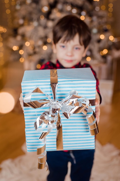 A boy with a New Year's gift under the tree lifestyle New Year and Christmas Festive decoration