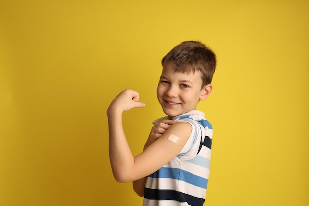 A boy with a patch on his arm after vaccination Space for text vaccination concept