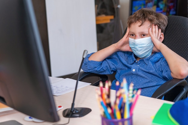 Boy with protective mask doing his homework