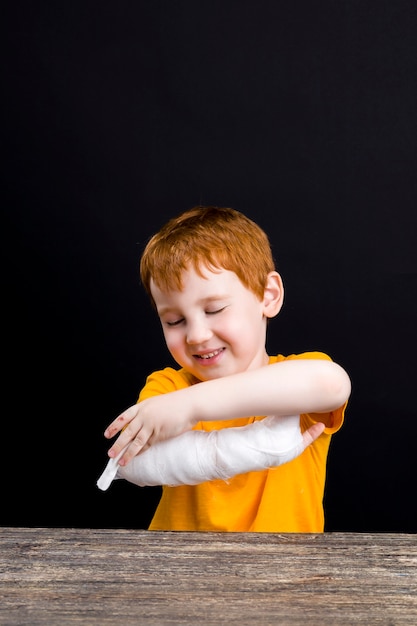 boy with red hair with a damaged hand and fingers  