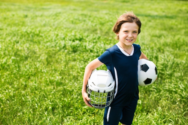 Boy with a soccer ball and a hockey helmet