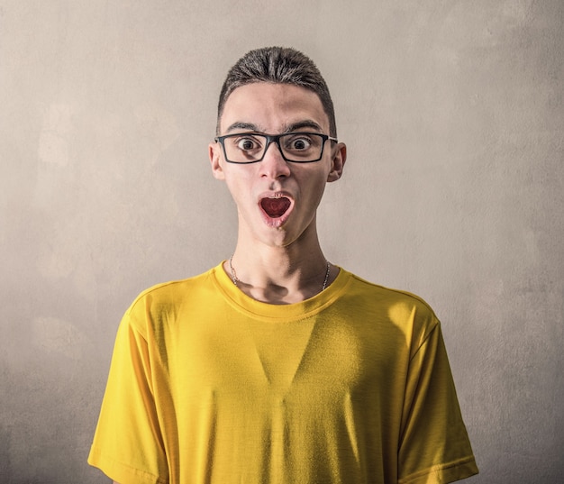 A Boy with yellow T-shirt and astonished expression