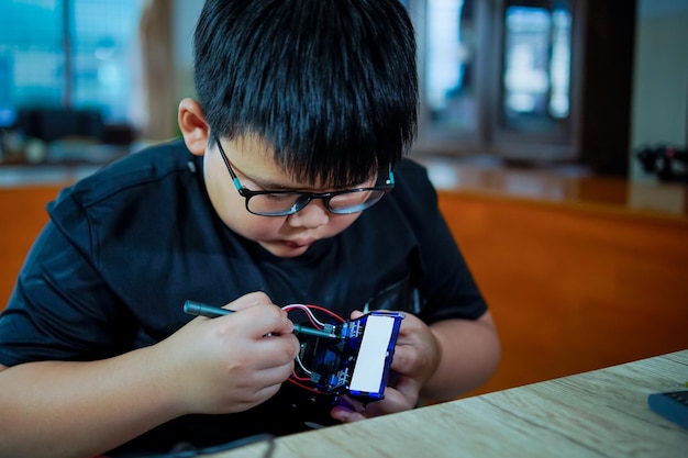 Boy working on technology experiment project at schooltechnology concept