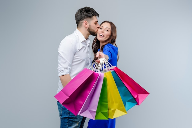 Boyfriend kisses girl with colorful shopping bags