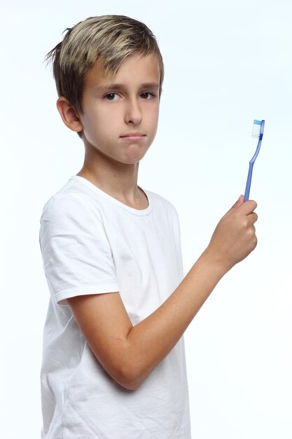 Boyholding a toothbrush isolated on white background