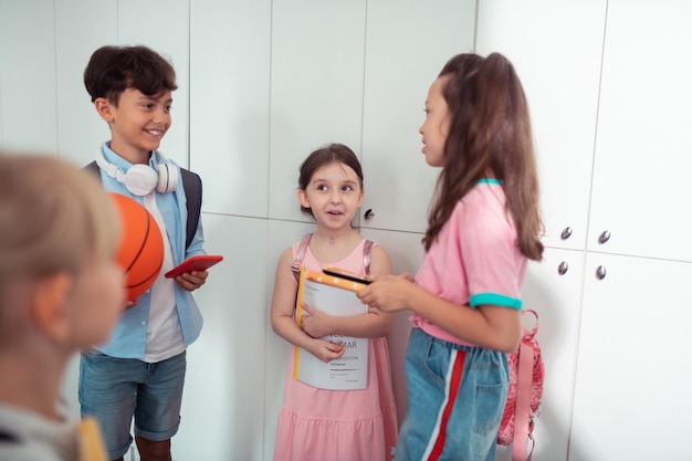 Boys and girls feeling cheerful while enjoying break at school