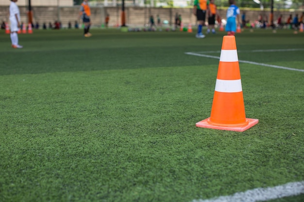 Boys Soccer ball tactics on grass field with cone