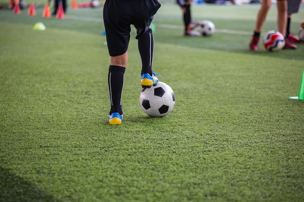 Boys Soccer ball tactics on grass field with cone