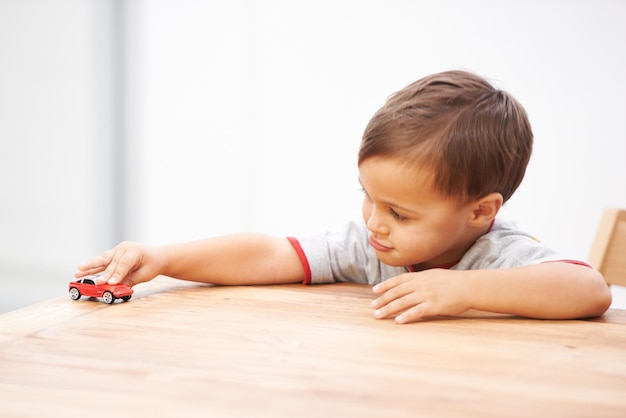 Boys and their toys Shot of a cute young boy playing with a toy car