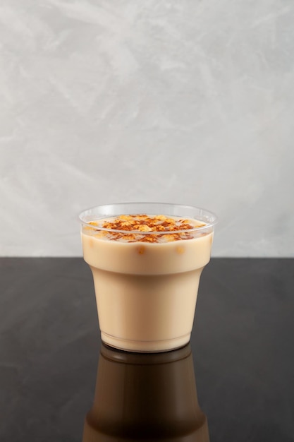 Boza or Bosa in disposable plastic take away cup Turkish drink with roasted chickpea