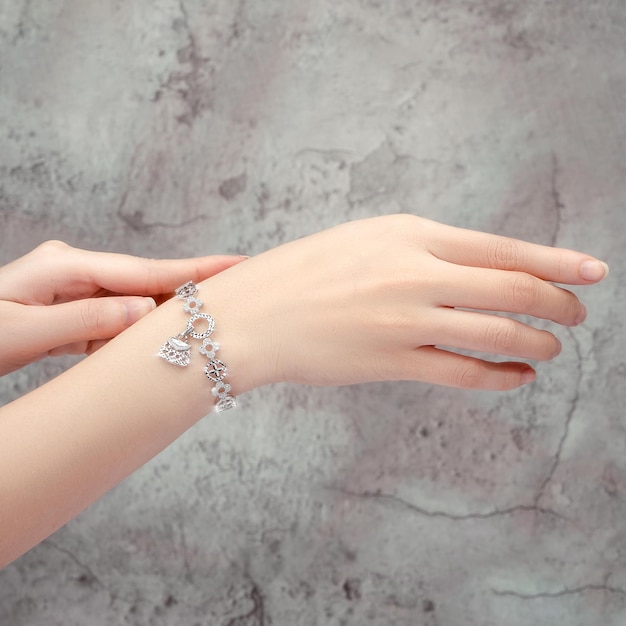 bracelet inlaid with a diamond on hand isolated on gray background