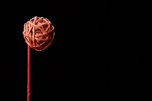 Braided red ball on a black background