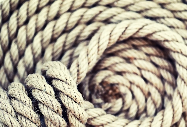 Photo braided thick rope tied in a skein. hemp rope for decoration and design. background from a fishing rope.