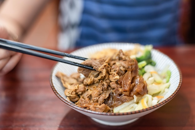 Braised pork on rice on table