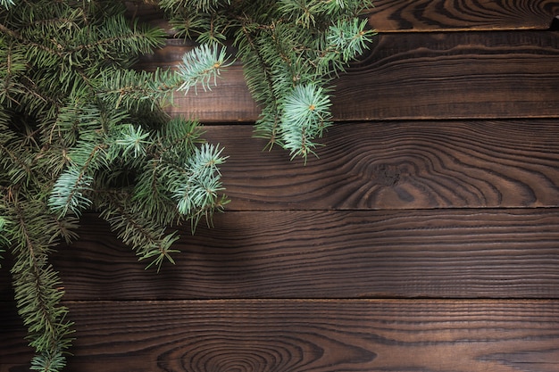 Branch of spruce on a wooden table. View from above