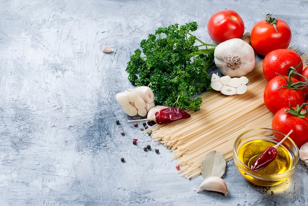 Branch tomatoes and herbs on grey background