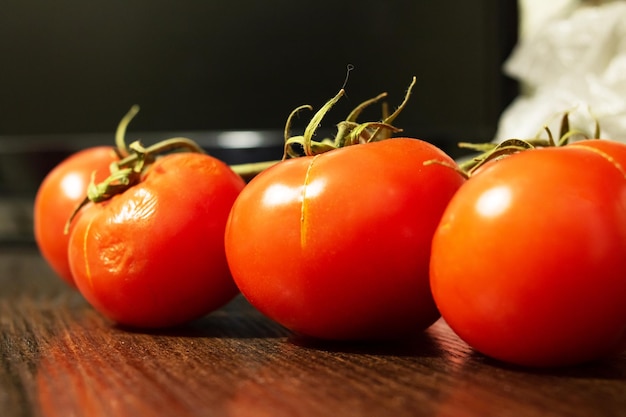 Branch with ripe red tomatoes on the table