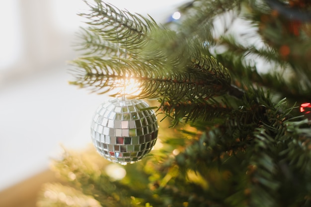 Branches of Christmas tree with balls toys lights decorations