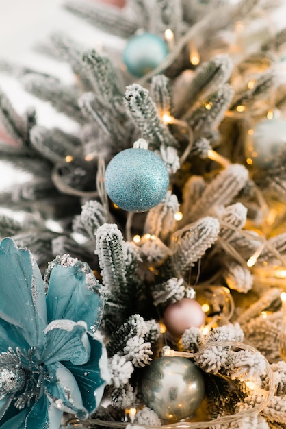 branches of the Christmas tree with New Year's toys are covered with snow.