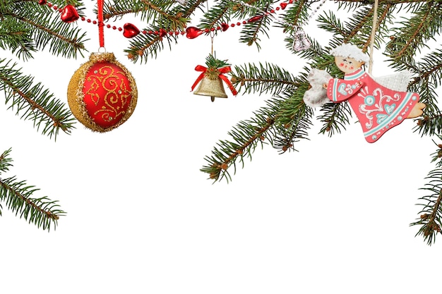 Branches of fir tree with toy ball, bell and other Christmas ornament on white isolated background