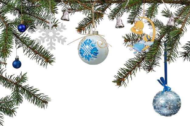 Branches of fir tree with toy balls, bells and other Christmas ornament on white isolated background.