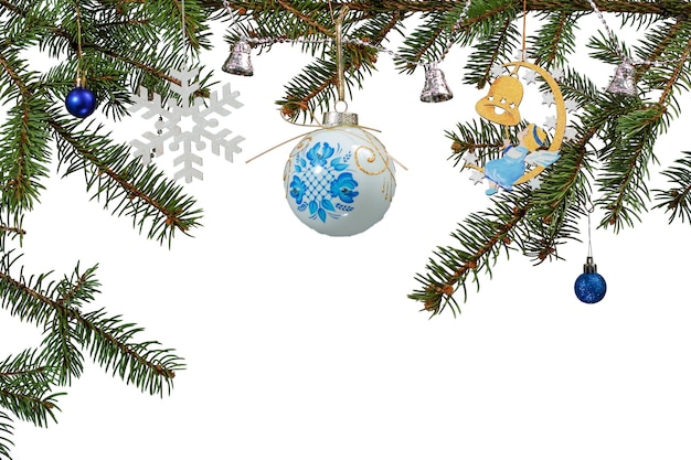 Branches of natural fir tree with balls, bells and other Christmas ornament on white isolated background. Greeting card concept.