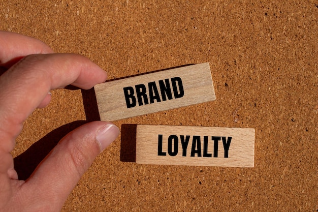 Brand loyalty words written on wooden blocks with brown background Conceptual brand loyalty symbol Copy space