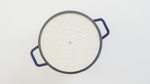 Brand new enameled cast iron covered dutch oven on a white background.