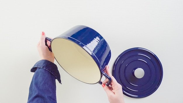 Brand new enameled cast iron covered dutch oven on a white background.