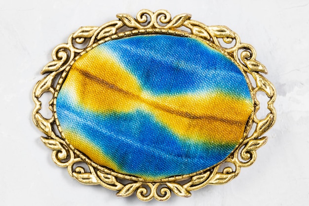 Brass brooch with handcolored silk batik on gray