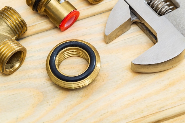 Photo brass fittings and adjustable wrench on wooden boards