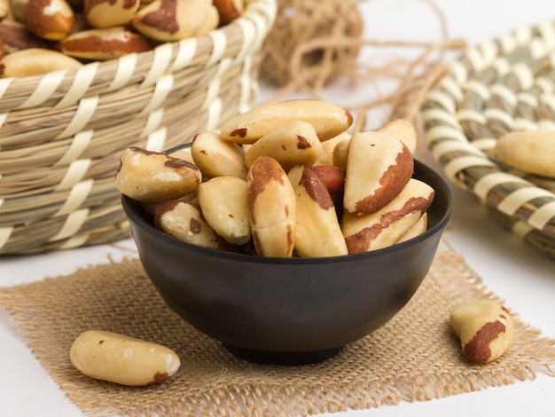 Brazil nuts served in a bowl isolated on napkin side view of nuts on grey background