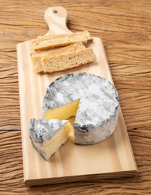 Brazilian artisan Lua Cheia cheese with toasts over wooden table