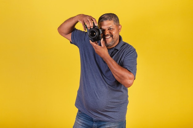 Brazilian black man adult holding photo camera photography hobby photographer