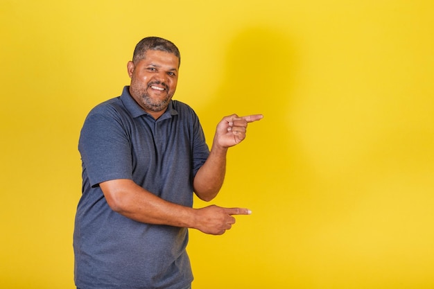 Brazilian black man adult smiling pointing to the right publicity photo