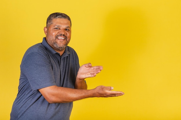 Brazilian black man adult smiling presenting something to the right publicity photo