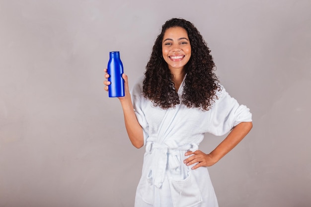 Brazilian black woman wearing bathrobe and towel curly hair spa beauty center hair care hair products