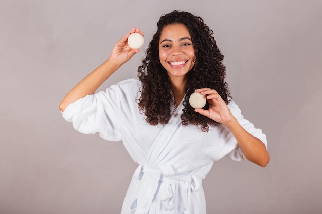 Brazilian black woman wearing bathrobe and towel vegan products for beauty and skin and hair care soaps Spa self care welfare