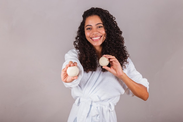 Brazilian black woman wearing bathrobe and towel vegan products for beauty and skin and hair care soaps Spa self care welfare