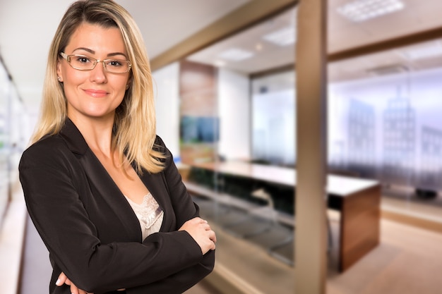 Brazilian business woman looking at camera in blurry office space. Copy space.