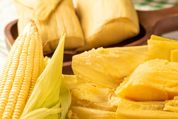 Brazilian corn snack pamonha and cornflower arranged on a table with green and white tablecloth selective focus