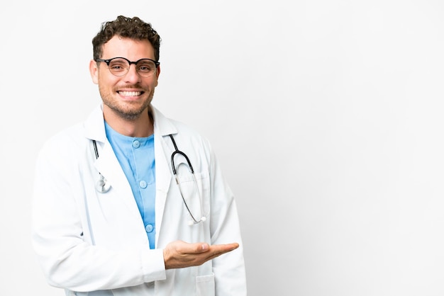 Brazilian doctor man over isolated white background presenting an idea while looking smiling towards