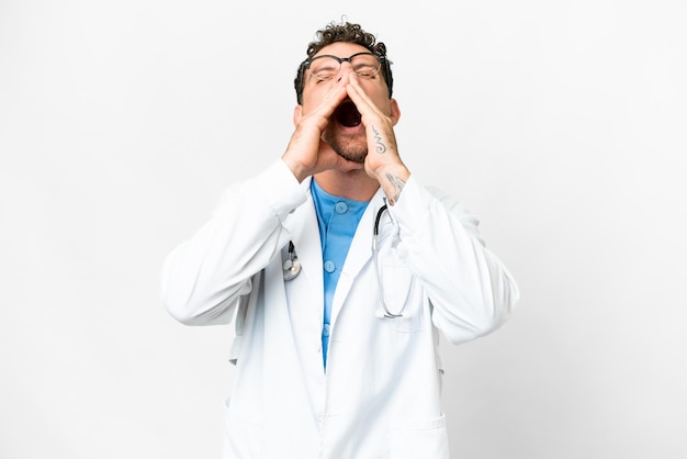 Brazilian doctor man over isolated white background shouting and announcing something