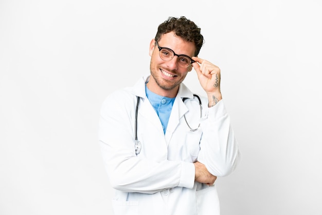 Brazilian doctor man over isolated white background with glasses and happy