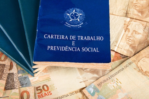 Brazilian document work and social security Carteira de Trabalho e Previdencia Social with Brazilian money banknotes