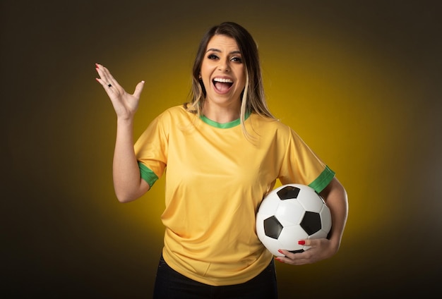 Brazilian fan Brazilian woman fan celebrating in soccer or soccer match on yellow background Brazil colors