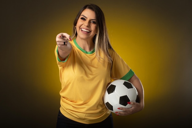 Brazilian fan Brazilian woman fan celebrating in soccer or soccer match on yellow background Brazil colors