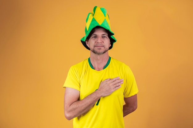 Brazilian fan with hand on chest singing the national anthem