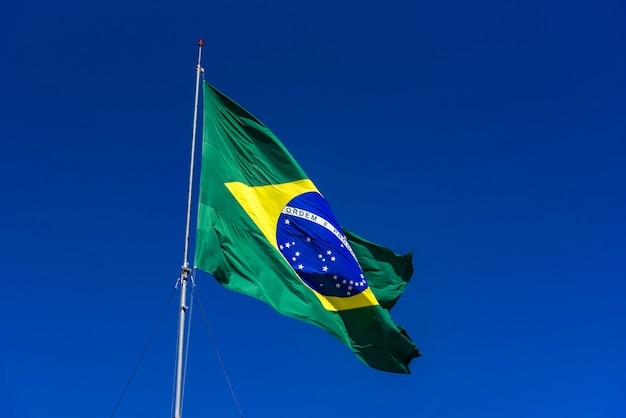 Brazilian flag hoisted with blue sky