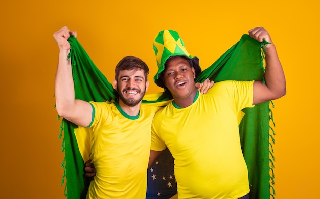 Brazilian friends latin americans diversity cheering for brazil world cup 2022 holding brazil flag football cheering and vibrating screaming goal joyful and happyxA